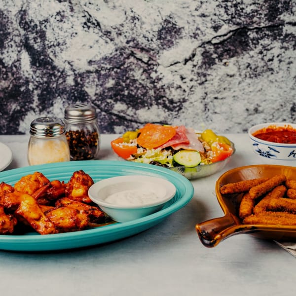 A spread of SilverLake Pizza & Pasta dishes: chicken wings, salad, mozzarella sticks, and marinara sauce.